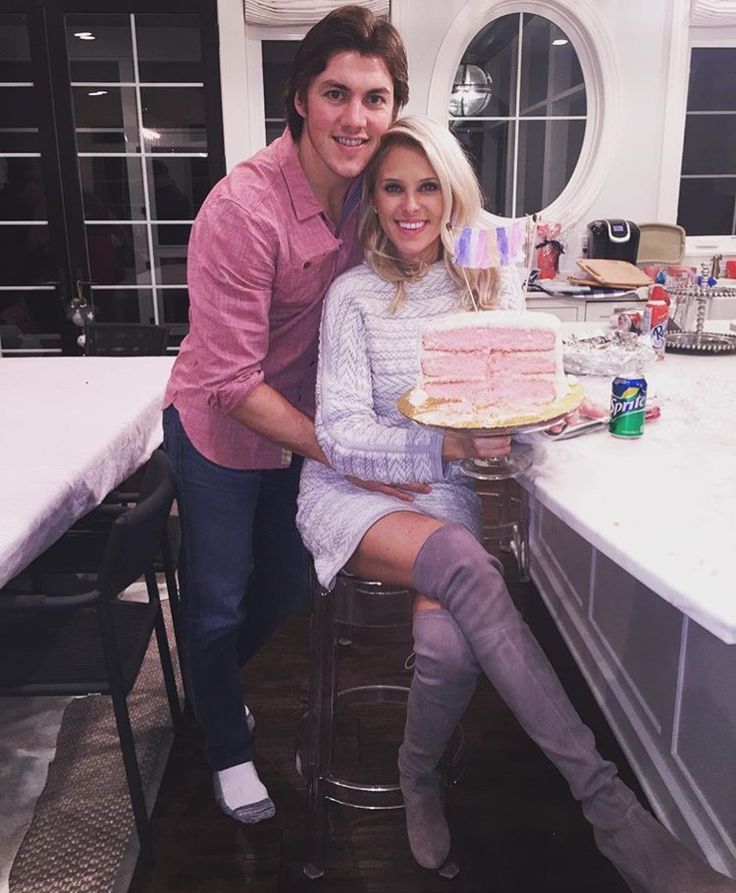 a man and woman sitting at a table with a cake in front of them on instagram