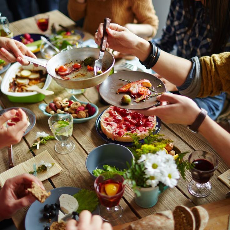 people sitting at a table eating pizza and salad