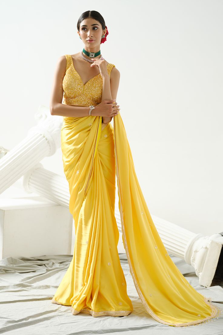 Yellow satin silk saree with bead, crystal placement embroidery. Paired with sequin embroidered blouse.
Components: 2
Pattern: Embroidery
Type Of Work: Bead, crystal, sequin
Neckline: Leaf neck
Sleeve Type: Sleeveless
Fabric: Satin Silk
Color: Yellow
Other Details: 
Back cut-out blouse
Occasion: Reception - Aza Fashions Crystal Placement, Satin Silk Saree, Placement Embroidery, Yellow Satin, Embroidered Saree, Beaded Leaf, Blouse For Women, Pattern Embroidery, Fashion App