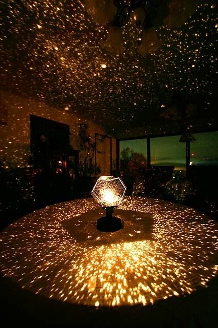 a room filled with lots of stars in the ceiling and lights shining on the floor