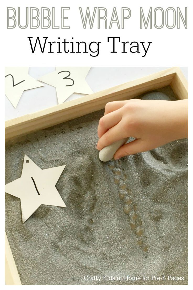 the writing tray is filled with sand and paper stars to make it look like a bubble wrap moon