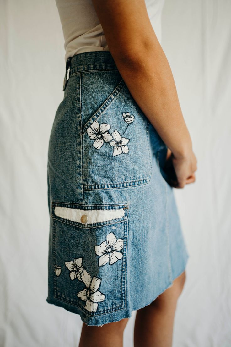 Hand painted denim skirt. Featuring hand painting floral artwork on all four pockets.  DKNY size small, machine washable.  Model shown is 5'4 and a size small. Casual Hand Painted Bottoms For Summer, Hand Painted Denim Bottoms For Summer, Hand Painted Casual Bottoms For Spring, Summer Cotton Hand Painted Bottoms, Hand Painted Cotton Bottoms For Summer, Hand Painted Cotton Summer Bottoms, Summer Hand Painted Cotton Bottoms, Painted Denim Skirt, Clothing Painting