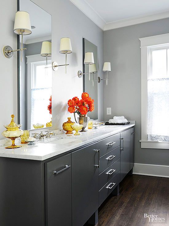 a bathroom with gray cabinets and white counter tops