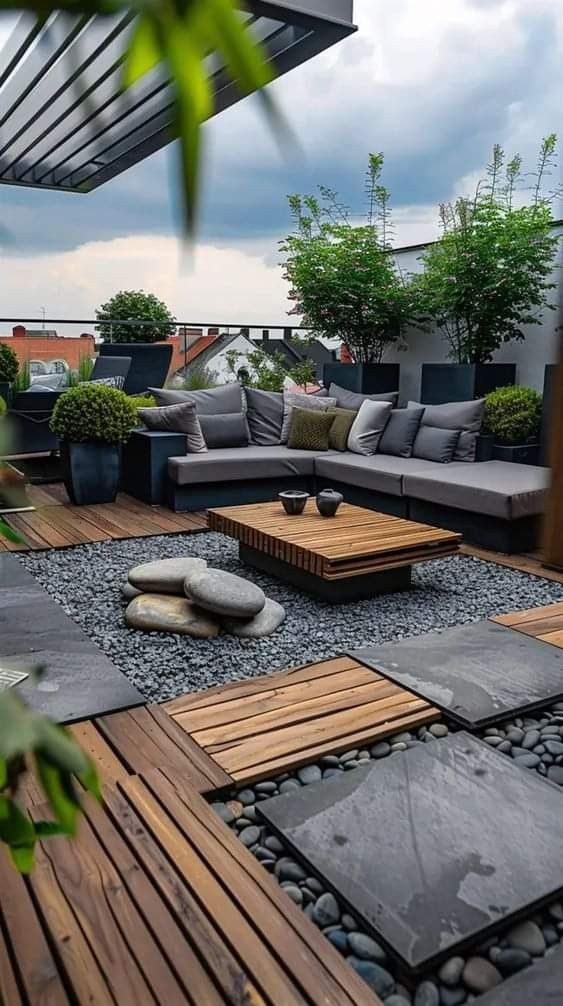 an outdoor living area with wooden flooring and stone seating on top of the roof