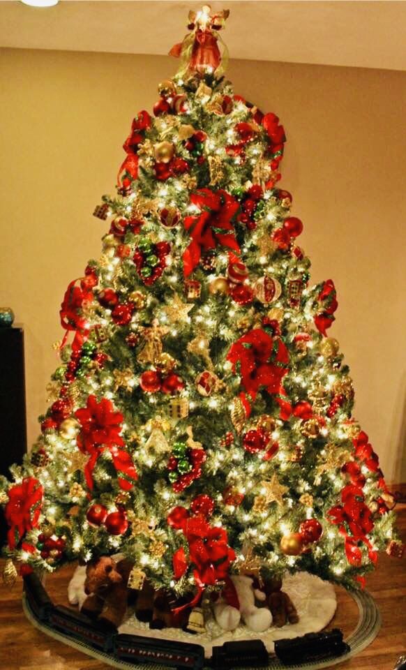 a christmas tree is decorated with red and gold ornaments