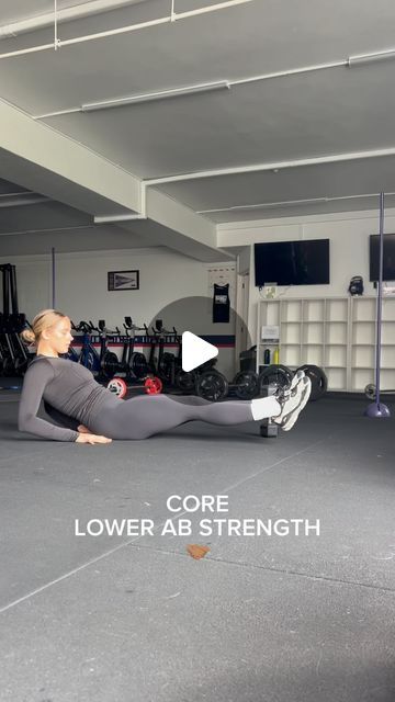 a woman is doing an exercise on the floor in a gym with her leg up