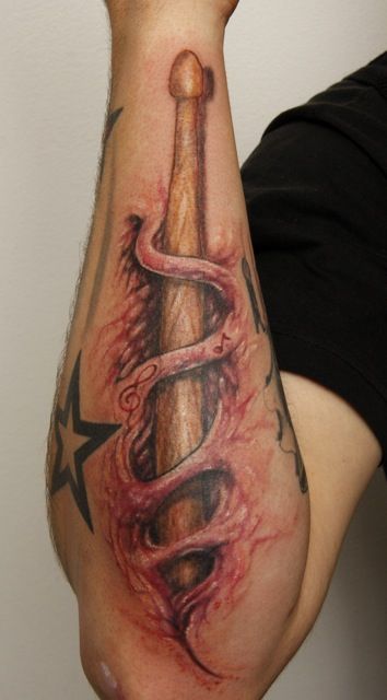 a man with a tattoo on his arm holding a baseball bat and snake wrapped around it