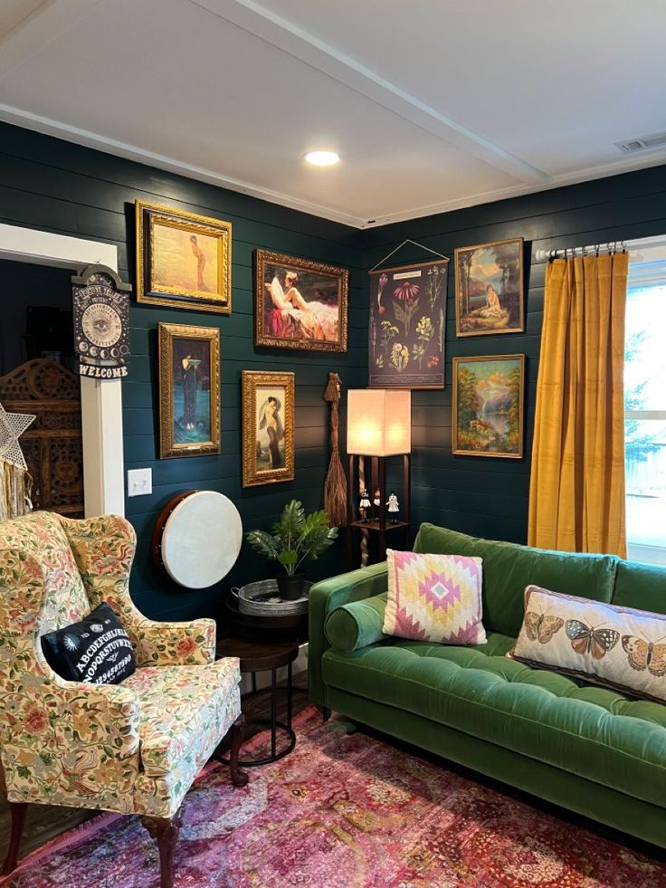 a living room with green couches and paintings on the wall above them, along with colorful rugs