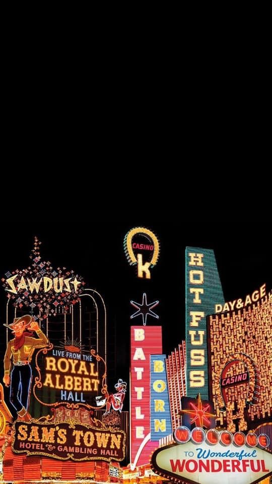 the las vegas sign is lit up at night with neon signs and buildings in the background