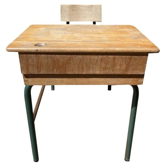 an old wooden desk with a chair on it's back legs and one leg missing