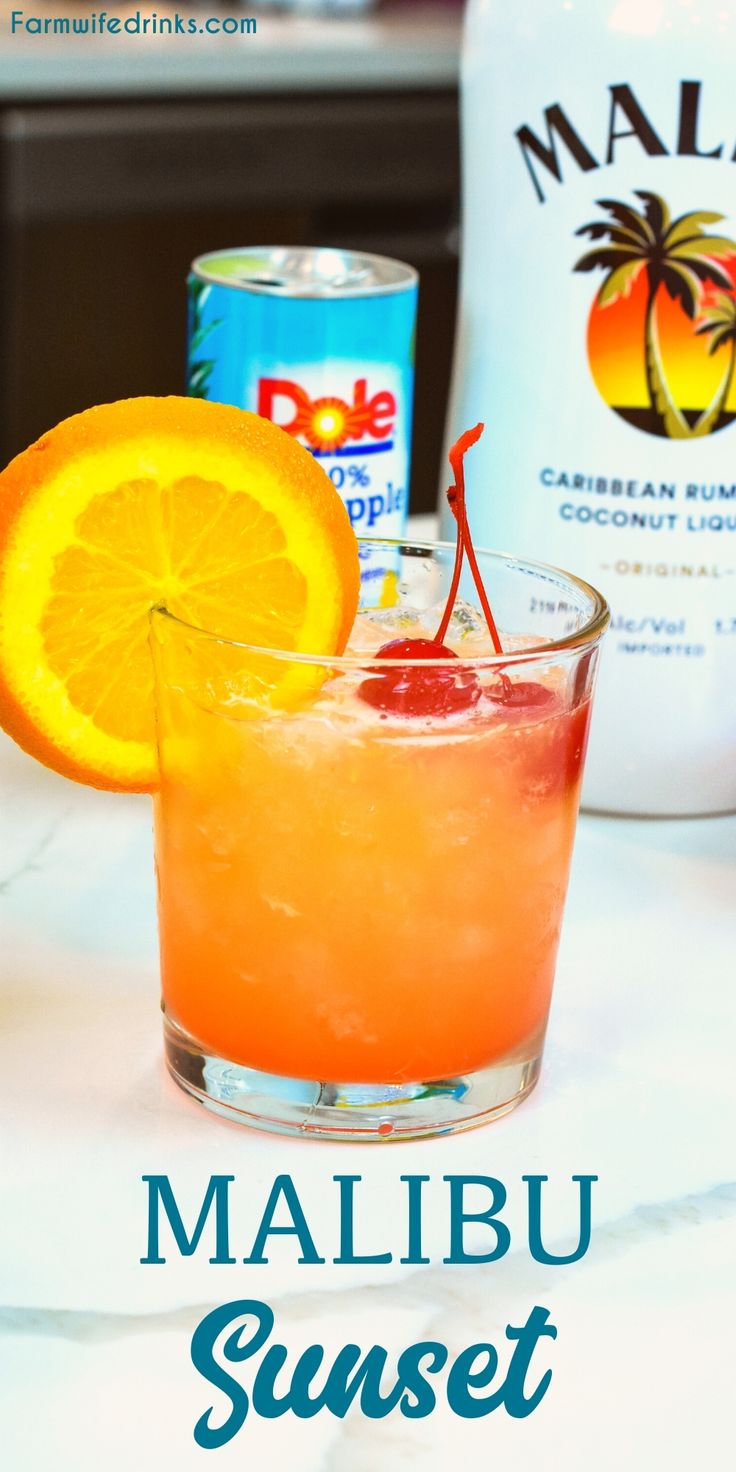 a close up of a drink in a glass with an orange slice on the rim