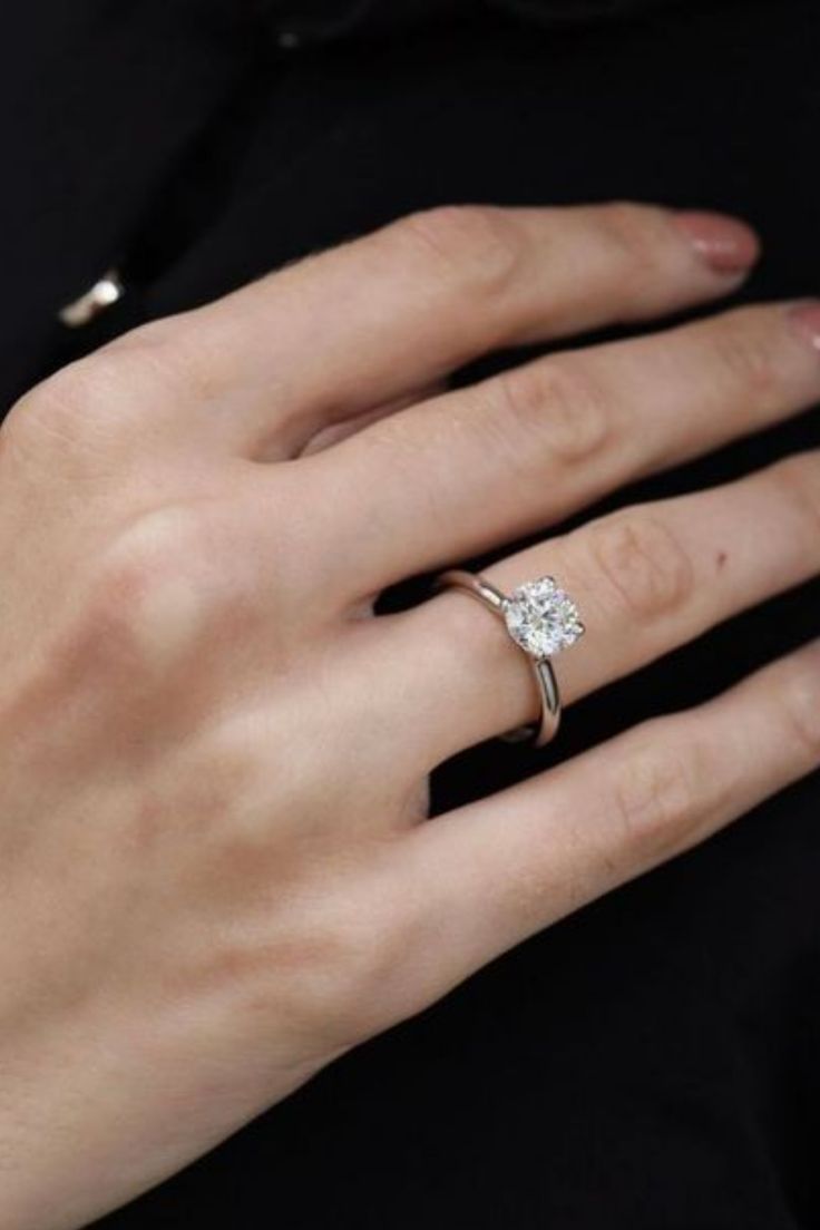 a woman's hand with a diamond ring on it