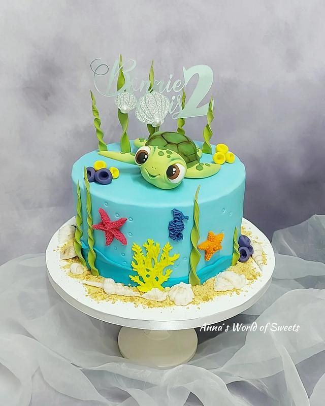 a blue cake decorated with sea animals and under the sea plants on top of it