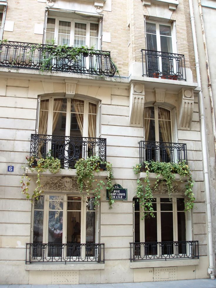 an apartment building with balconies and plants on the windows