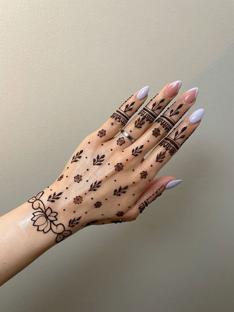 a woman's hand with henna tattoos on it