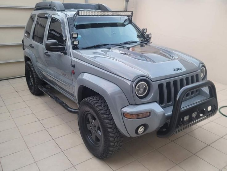 a grey jeep is parked in a garage