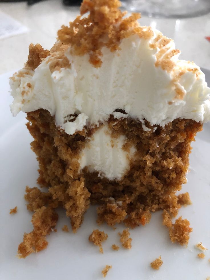 a close up of a piece of cake on a plate with whipped cream and crumbs