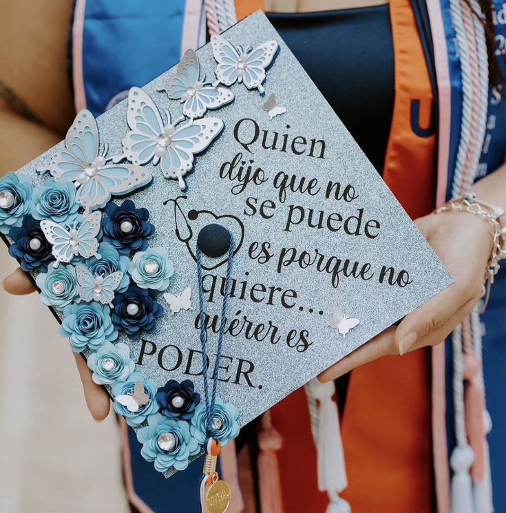 a person holding a graduation cap with flowers on it