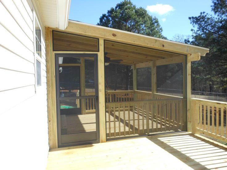 a screened porch with sliding glass doors and railings on the side of a house