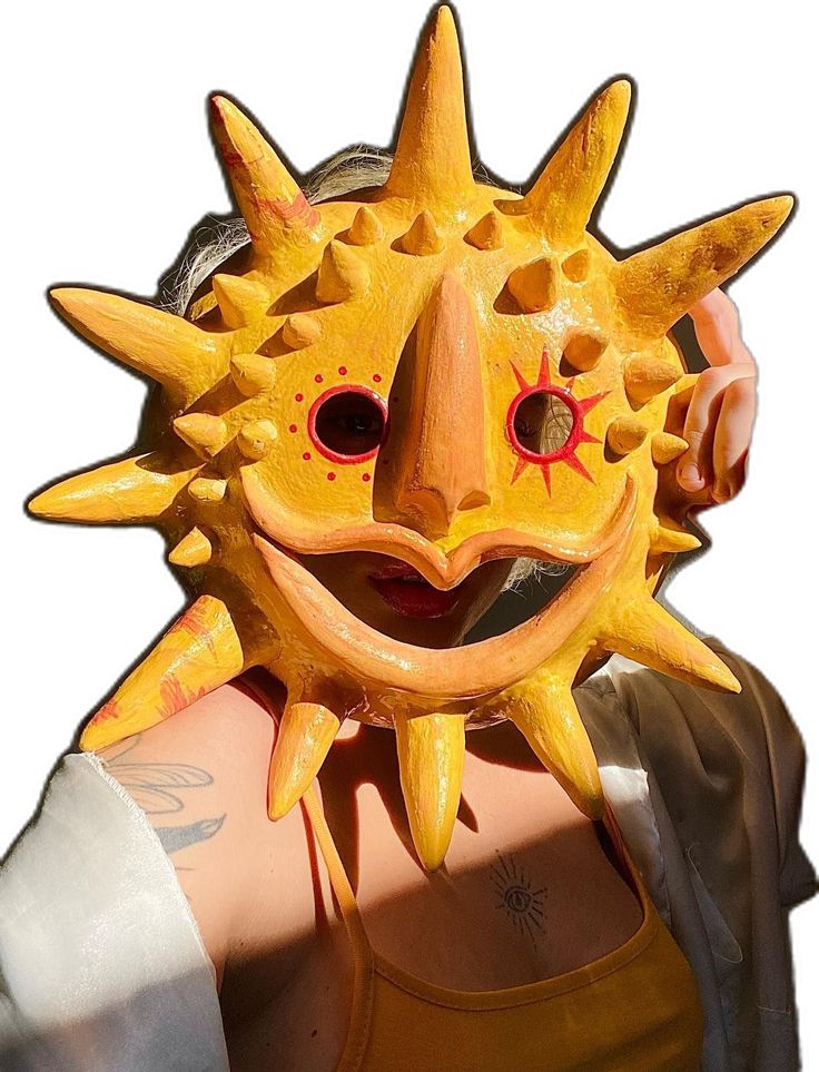 a person wearing a yellow mask with spikes on their head