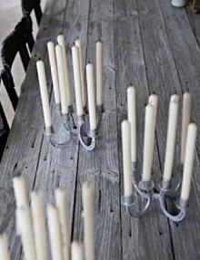 there are many candles that are on the wooden table and one candle is turned upside down