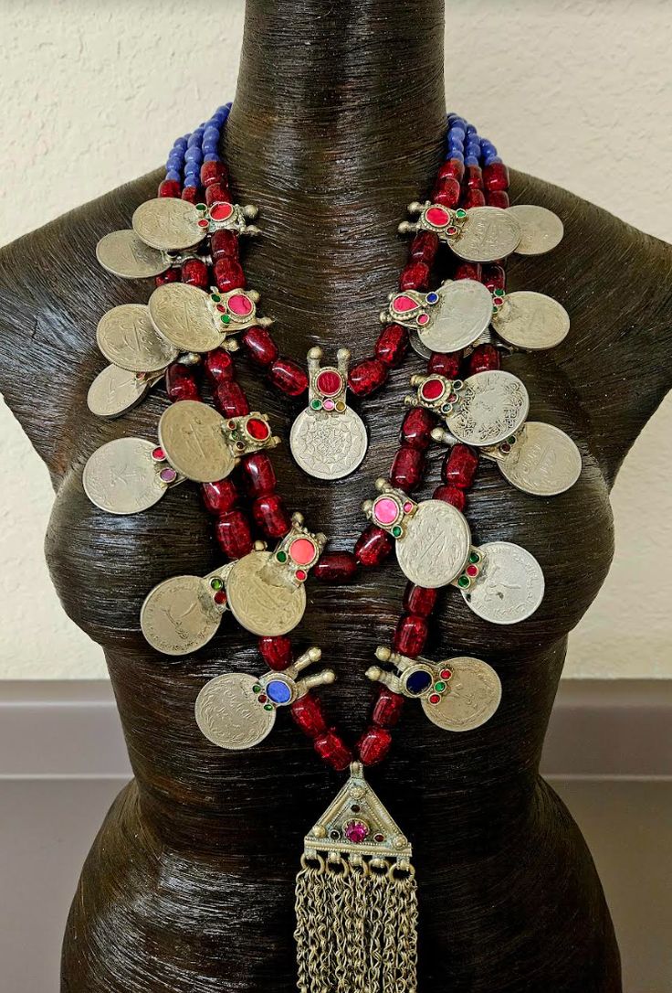 This gorgeous triple strand beaded tribal - ethnic chest piece is of moderate weight. Three strands of ruby red Czech barrel glass and purple agate beads separate the inlaid glass Architectural coins and complete the back. A very rare, vintage, double Waziri or Kuchi scroll pendant is the focal point of the piece with completely intact chain dangles and inlaid glass. The pendant measures 9.5" x 3.5". The back is finished with silver tone hardware, a lobster claw clasp and a 3" extender chain with a coin accent. This adjusts from 20-23". OOAK Wearable Art from the Atelier of Kat Kouture! Traditional Red Beads For Festival, Red Bohemian Necklaces For Traditional Ceremonies, Bohemian Red Necklaces For Traditional Ceremonies, Bohemian Beads For Traditional Ceremonies And Festivals, Traditional Red Beaded Necklace For Rituals, Red Bohemian Necklace For Ceremonial Occasions, Jewellery Shop Design, Turquoise Western, Chest Piece