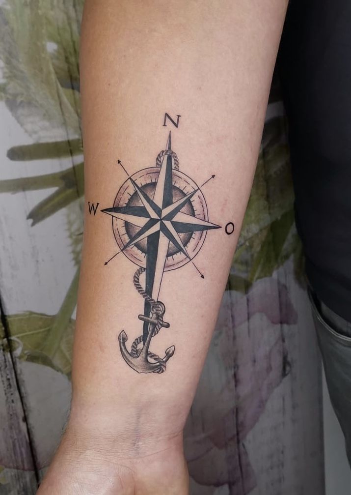 a compass and anchor tattoo on the arm