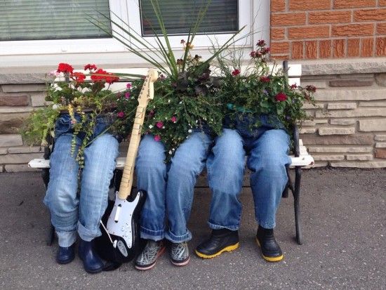 three people sitting on a bench with plants in their lap and one holding a guitar