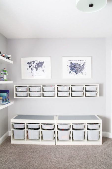 a room with several bins on the wall and pictures hanging above it, along with other storage containers