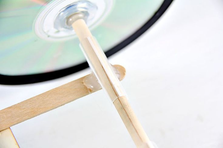 a close up of a wooden chair with a cd on the back and a blurry background