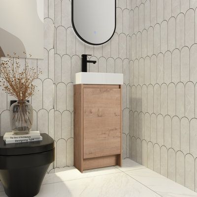 a bathroom with a sink, mirror and toilet paper dispenser in it