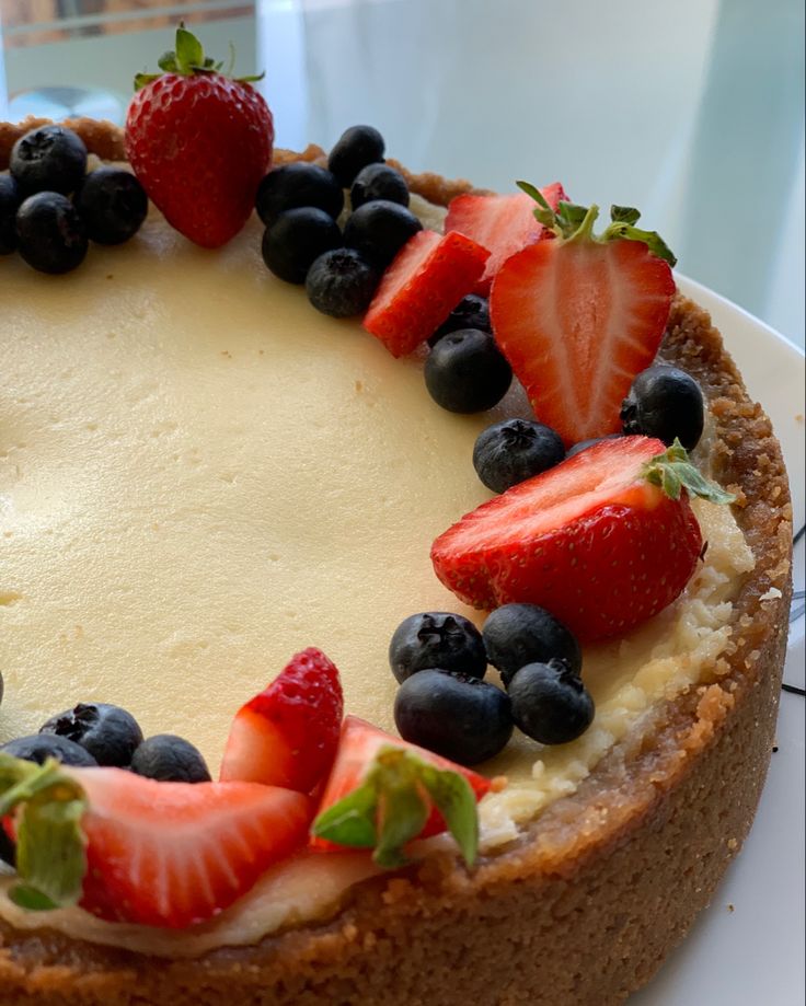 a cheesecake with strawberries and blueberries on top