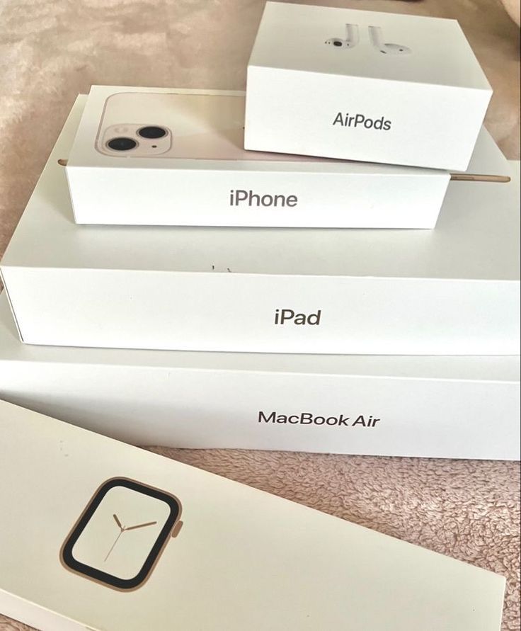 three apple products are sitting on top of each other in their boxes, one is gold and the other is silver