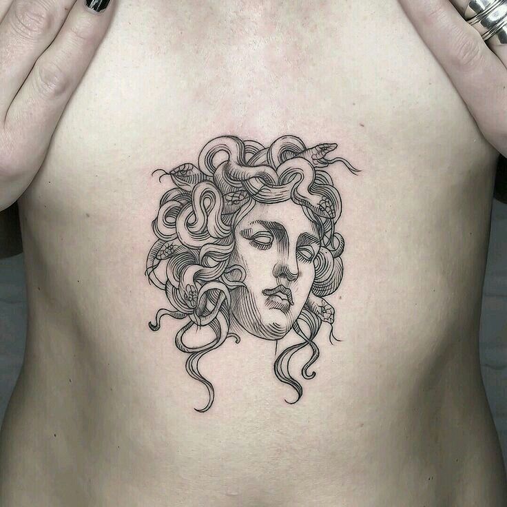 a woman's chest with an intricate tattoo design on it