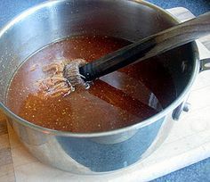 a metal pot filled with liquid and a brush in it's handle that says dad mop sauce