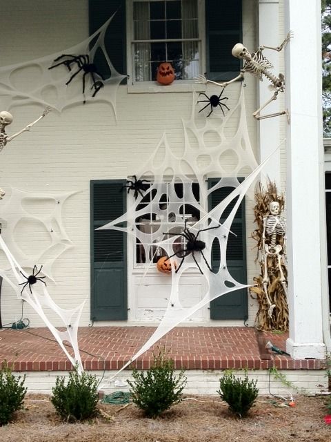 a house decorated for halloween with spider webs and pumpkins