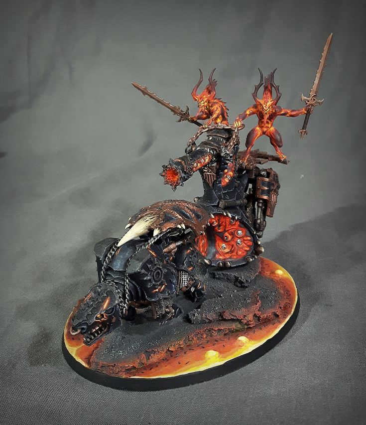 a miniature model of a demon riding a motorcycle with flames on its body and two swords in his hand