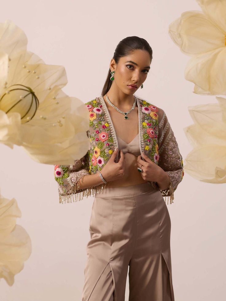 Dress up in one of the trendiest and out and about - cape set! This ensemble features exceptional craftsmanship and modern cuts with a plunge neckline modal satin solid blouse and heavenly floral resham embroidered cape . It comes with modal satin pants. Party Sets With Sheer Dupatta For Spring, Spring Party Sets With Sheer Dupatta, Spring Party Palazzo Set With Sheer Dupatta, Embroidered Sets For Spring Evening, Elegant Front Open Sets For Eid, Spring Festive Party Wear Sets, Festive Party Wear Sets For Spring, Chic Festive Sets With Traditional Drape, Chic Festive Set With Traditional Drape