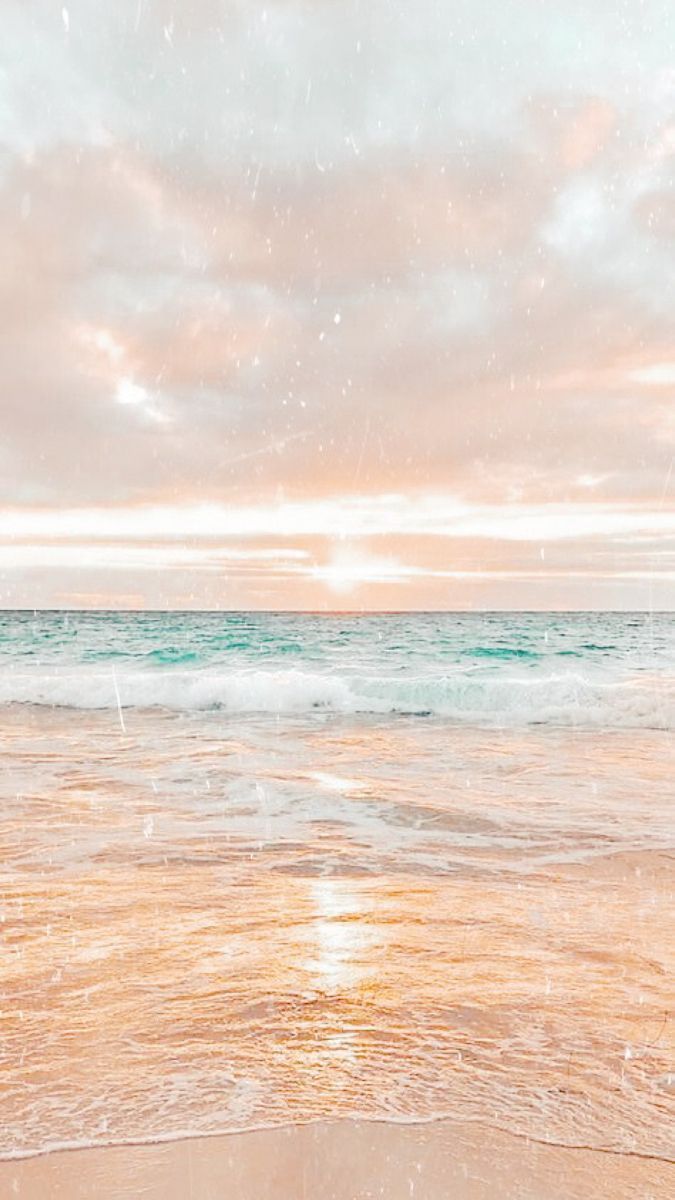 an ocean beach with waves coming in to shore and the sun shining on the water