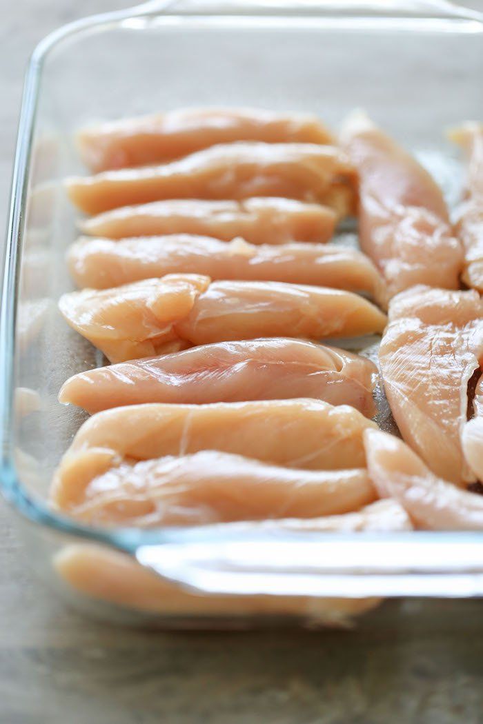 several pieces of raw chicken in a glass dish