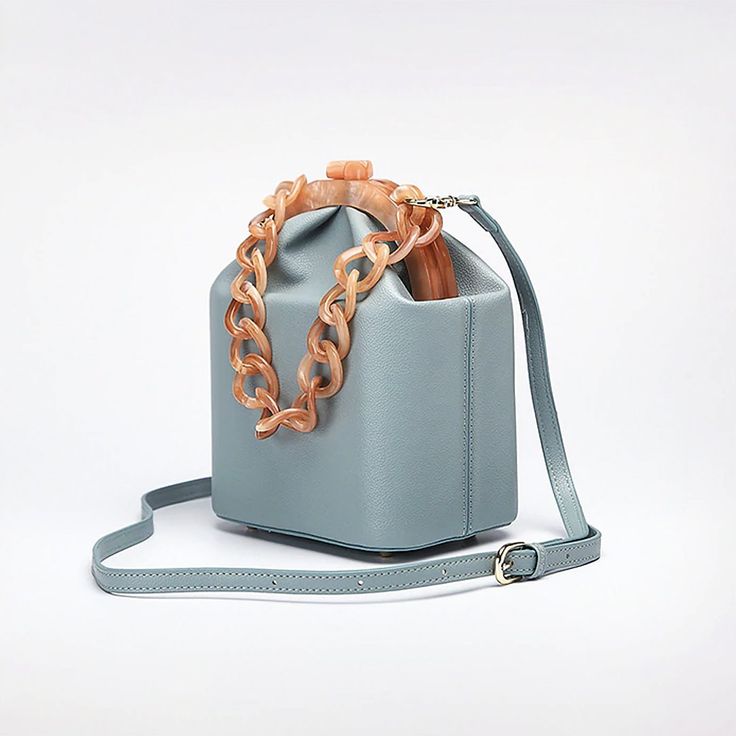 The Jade Mini Bucket Bag is crafted in smooth vegan leather featuring a contrasting faux tortoiseshell chain and frame in apricot color, kiss-lock closure, and a detachable shoulder strap. This timeless addition to your accessories edit can be carried by the top chain or as a crossbody with the detachable shoulder strap. Nude, White, Blue Sea, Leopard & Jade colors available. Vegan Leather Kiss-lock closure Imported Purse Aesthetic, Lady Dior Handbag, Expensive Bag, Beaded Clutch Bag, Apricot Color, Luxury Bags Collection, Mini Bucket Bag, Mini Bucket Bags, Girly Bags