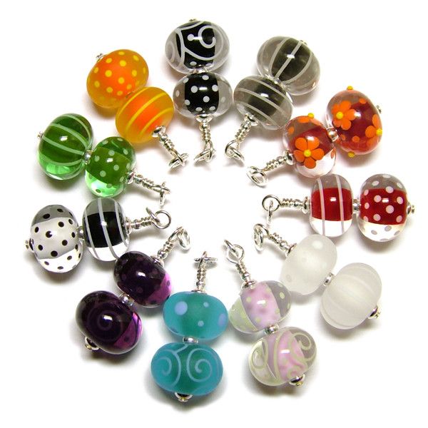 a bunch of different colored glass beads on a white surface with polka dots and swirls