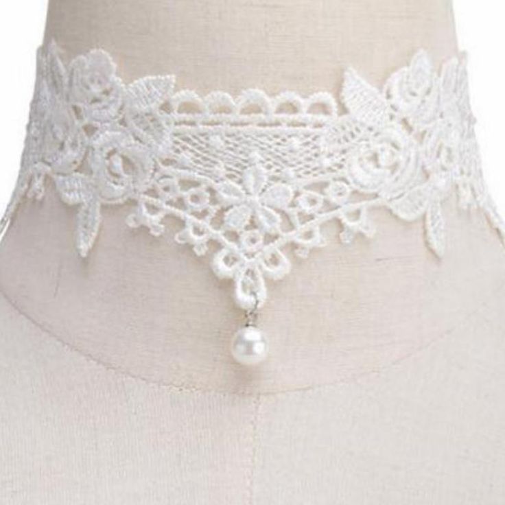 A simply lovely soft lace choker necklace featuring a dainty pearl dangle bead at the center. This choker gives a soft and romantic feel to your outfit and is really very pretty. Features an adjustable clasp closure. White Pearl Charm Choker For Party, Elegant Adjustable Cream Choker, Adjustable Elegant Cream Choker, Elegant Cream Adjustable Choker, Adjustable Pearl Charm Choker For Party, Delicate White Choker, White Pearl Drop Choker, Vintage Adjustable Pearl Choker, Delicate Adjustable Pearl White Choker