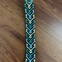 a beaded bracelet on a wooden table