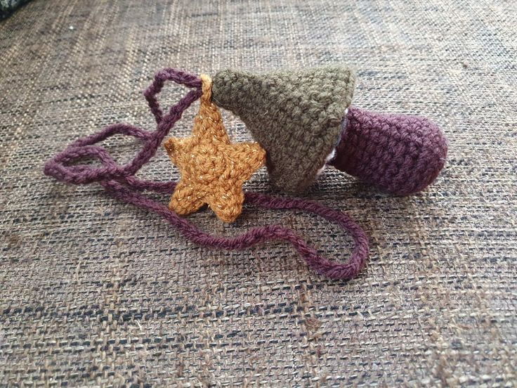 three crocheted objects are laying on the ground together, one is a star