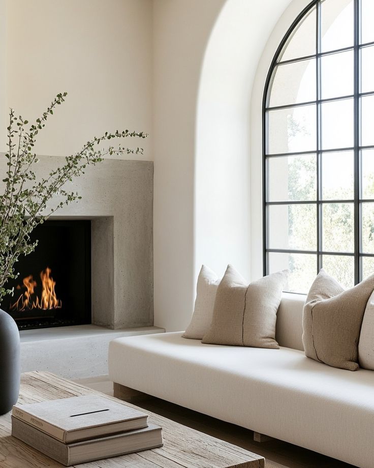 a living room filled with furniture and a fire place in front of a large window