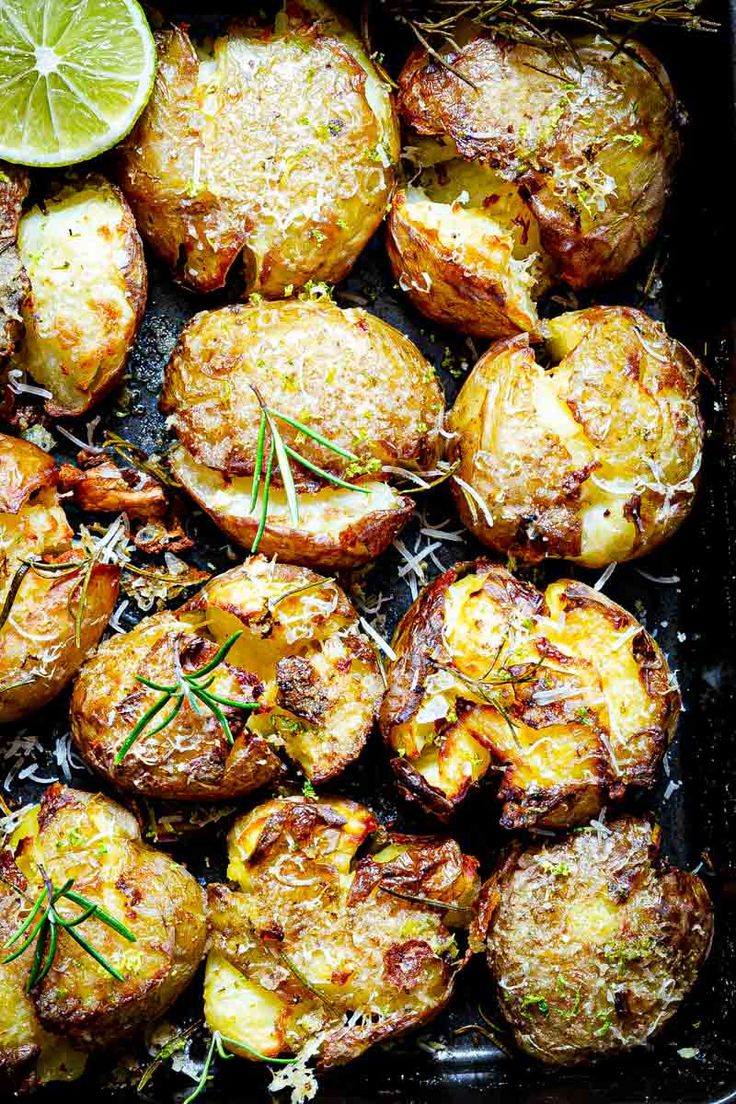 baked potatoes with herbs and lemons in a baking dish, ready to be eaten