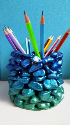 there are many pencils in the cup that is made out of rocks and candy