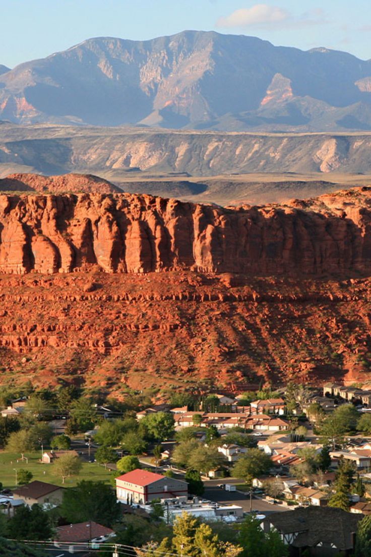 the mountains are covered in red rocks and houses