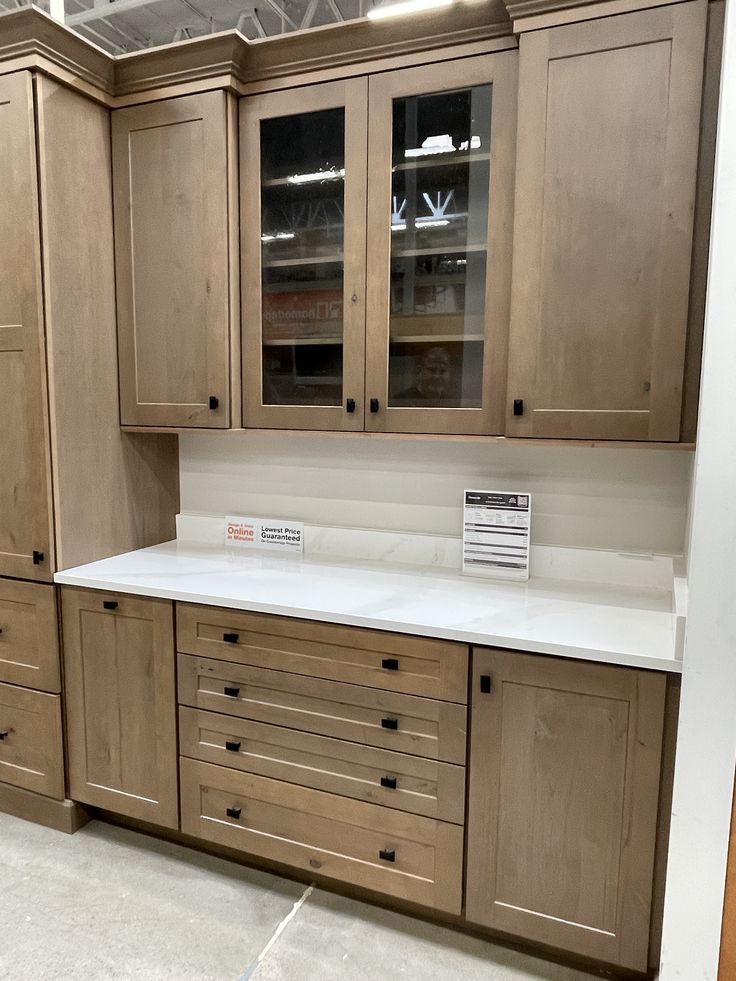 an empty kitchen with wooden cabinets and white counter tops in a showroom or office